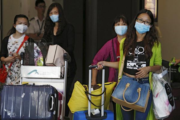 Sejumlah turis yang datang dari Seoul, Korsel, terlihat memakai masker di bandara Hong Kong - Reuters