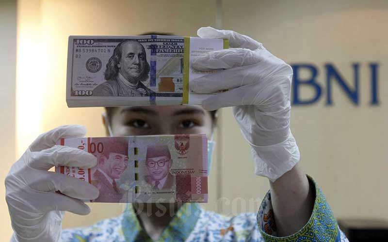 Karyawati menunjukan Uang Rupiah dan Dollar AS di salah satu kantor cabang Bank BNI di Jakarta, Kamis (3/9/2020).  Bisnis - Himawan L Nugraha