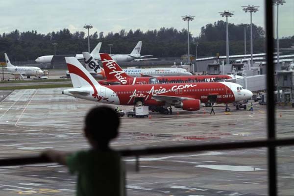 Seorang anak memperhatikan sejumlah pesawat yang tengah parkir di Bandara Intenasional Changi di Singapura - Reuters/Edgar Su