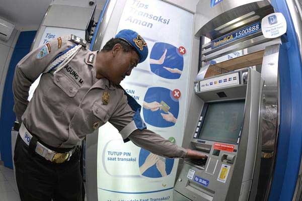 Ilustrasi - Petugas kepolisian memeriksa mesin Anjungan Tunai Mandiri (ATM) di sebuah pusat perbelanjaan di kawasan Kuta, Bali, Senin (26/3/2018). - Antara/Fikri Yusuf
