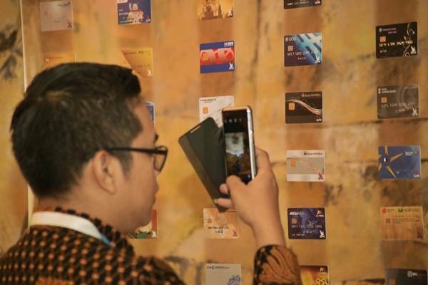 Pengunjung mengamati kartu berlogo Gerbang Pembayaran Nasional di sela-sela peluncurannya di Jakarta, Kamis (3/5/2018). - JIBI/Felix Jody Kinarwan 