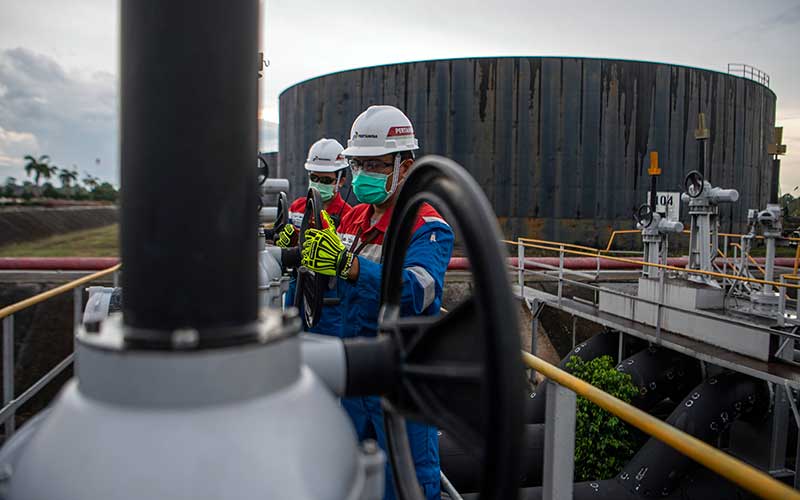 Pekerja PT Pertamina Hulu Rokan mengontrol kerangan pipa minyak yang menuju tangki pengumpul produksi minyak (Tank Farm) di Blok Rokan, Dumai, Riau, Rabu (22/12/2021). ANTARA FOTO - Nova Wahyudi