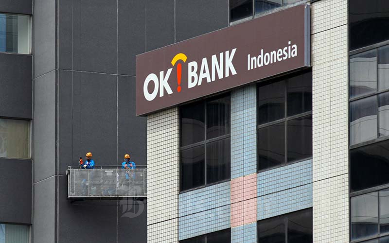 Pekerja melakukan perawatan gedung di dekat logo Bank Oke Indonesia di Jakarta, Jumat (12/11/2021). Bisnis - Arief Hermawan P