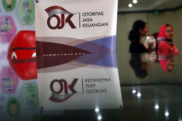 Karyawan melintas di dekat logo Otoritas Jasa Keuangan (OJK) di Jakarta, Rabu (3/10/2018). - JIBI/Nurul Hidayat