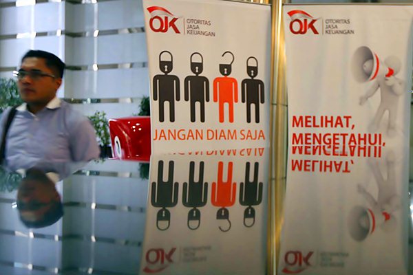 Karyawan melintas di dekat logo Otoritas Jasa Keuangan (OJK) di Jakarta. - JIBI/Nurul Hidayat
