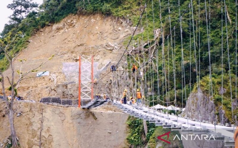 Pengerjaan jembatan gantung Gladak Perak di Kabupaten Lumajang, Jatiim, terdampak awan panas Gunung Semeru, yang ditargetkan rampung sebelum Lebaran 2022. - Antara/Diskominfo Lumajang.