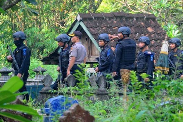 Sejumlah polisi berjaga di sekitar tempat pemakaman saat proses autopsi jenasah terduga teroris Siyono di Brengkungan, Pogung, Cawas, Klaten, Jawa Tengah - Antara