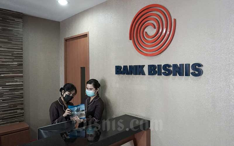 Karyawan beraktivitas di dekat logo PT Bank Bisnis Internasional Tbk. (BBSI) di Jakarta, Jumat (28/1/2022). Bisnis - Suselo Jati
