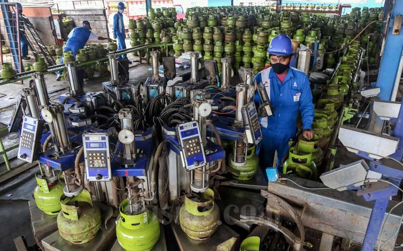 Petugas melakukan tahap pengisian LPG pada tabung gas 3kg di SPBE Srengseng, Jakarta, Senin (1/2/2021). Bisnis - Eusebio Chrysnamurti