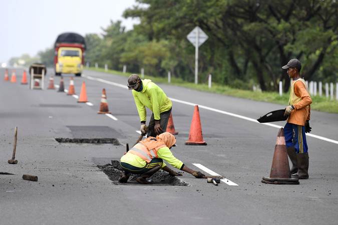 Pekerja menyelesaikan perbaikan jalan tol Brebes-Pejagan, Jawa Tengah, Minggu (12/5/2019). - ANTARA/Puspa Perwitasari