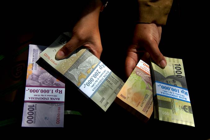 Warga menunjukkan uang rupiah pecahan kecil di Lapangan Karebosi, Makassar, Sulawesi Selatan, Senin (13/5/2019).  - Antara/Abriawan Abhe