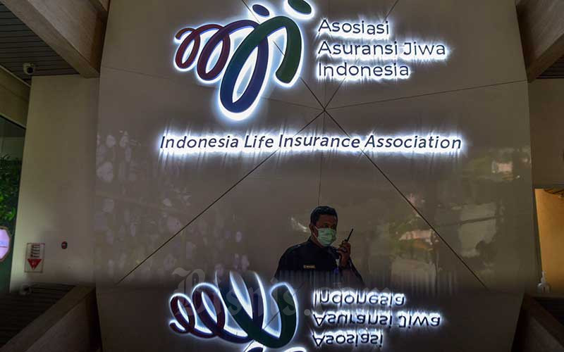Karyawan beraktivitas di dekat logo-logo asuransi jiwa di kantor Asosiasi Asuransi Jiwa Indonesia (AAJI), Jakarta, Kamis (23/12/2021).  - Bisnis/Fanny Kusumawardhani