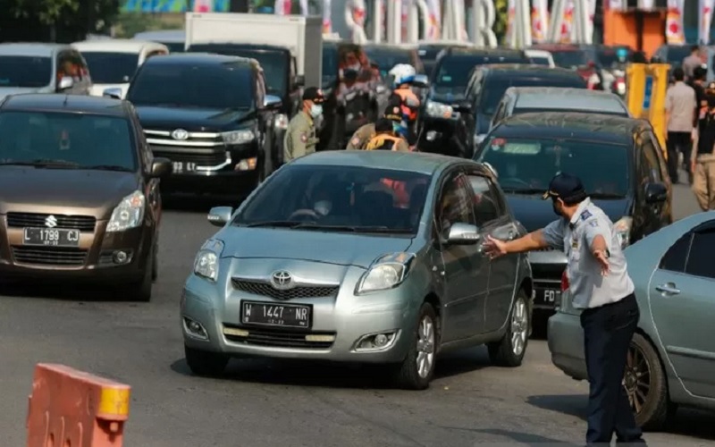 Petugas mengatur lalu lintas kendaraan yang akan masuk ke Kota Surabaya jelang Hari Raya Lebaran, Kamis (6/5/2021). - Antara 