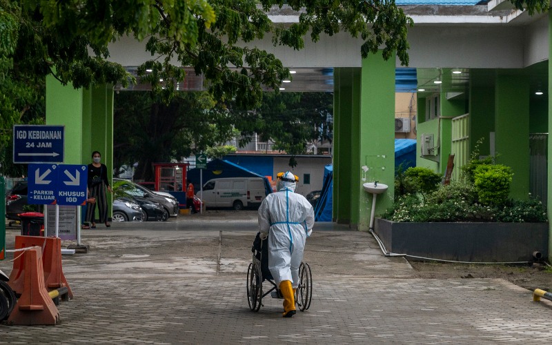 Seorang tenaga medis mendorong seorang pasien dengan kursi roda di Rumah Sakit Umum (RSU) Anutapura di Palu, Sulawesi Tengah, Sabtu (17/7/2021). Rumah sakit yang dikelola Pemerintah Kota Palu itu terpaksa menutup sementara layanan pada ruang intermediate, Poli Saraf dan Poli Telinga, Hidung dan Tenggorokan (THT) untuk meminimalisir penyebaran virus corona menyusul terinfeksinya 12 tenaga kesehatan di rumah sakit tersebut. - ANTARA FOTO/Basri Marzuki