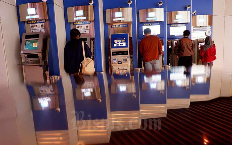 Nasabah melalukan transaksi lewat mesin anjungan tunai mandiri (ATM) milik PT Bank Central Asia Tbk (BCA) di Jakarta, Senin (9/7/2018). Bisnis - Nurul Hidayat