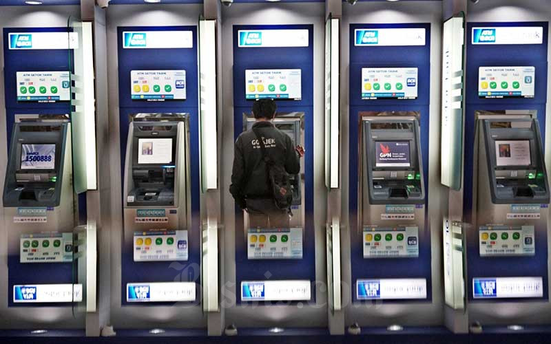 Nasabah melakukan transaksi lewat mesin anjungan tunai mandiri (ATM) di Tangerang Selatan, Banten, Sabtu (28/3/2020). Bisnis - Eusebio Chrysnamurti