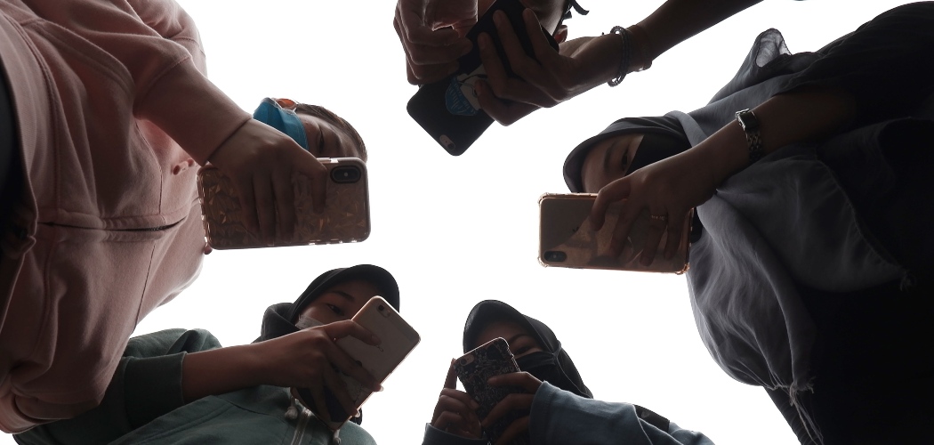 Sejumlah remaja menggunakan ponsel saat berkomunikasi di Medan, Sumatera Utara, Jumat (17/4/2020). - ANTARA FOTO/Septianda Perdana
