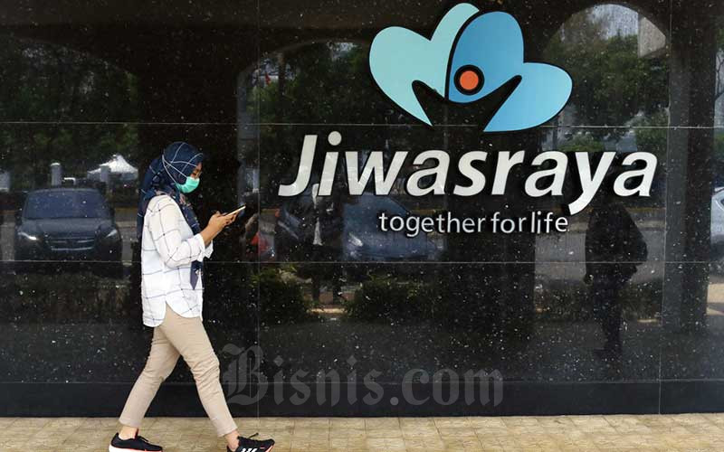 Warga melintasi logo Asuransi Jiwasraya di Jakarta, Senin (5/10/2020). Bisnis - Eusebio Chrysnamurti