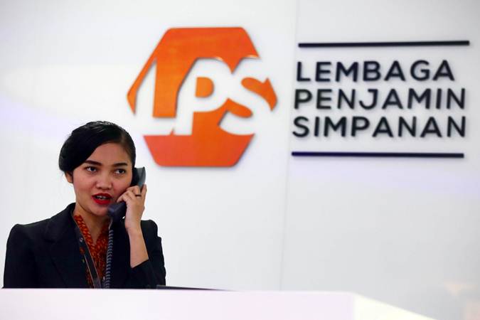 Karyawan beraktivitas di dekat logo Lembaga Penjamin Simpanan (LPS) di Jakarta, Selasa (23/4/2019). - Bisnis/Abdullah Azzam