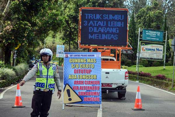 Polisi mengatur lalu lintas di Jalur Puncak Gunung Mas Kabupaten Bogor, Jawa Barat, Senin (19/2/2018). - ANTARA/Raisan Al Farisi