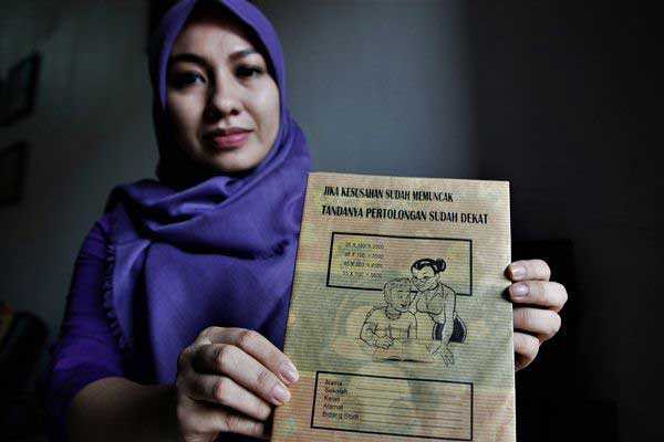 Seorang ibu memerlihatkan sampul buku siswa yang mengandung unsur pornografi, di Kendari, Sulawesi Tenggara, Kamis (13/7). - ANTARA/Jojon