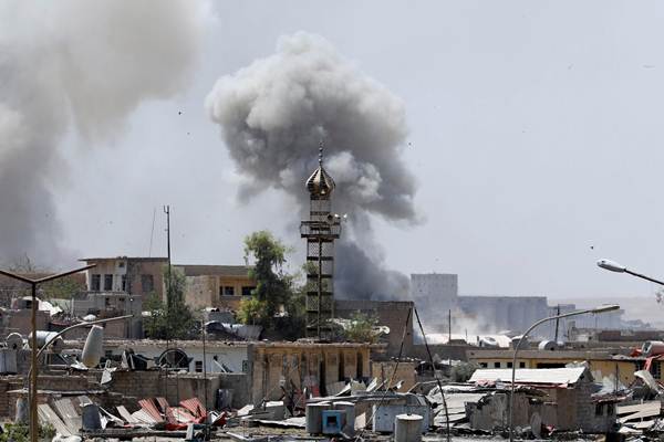 Asap mengepul dari posisi militan Negara Islam (IS) setelah serangan artileri oleh pasukan Irak di Mosul barat, Irak pada 18 Juni 2017. REUTERS  -  Erik De Castro