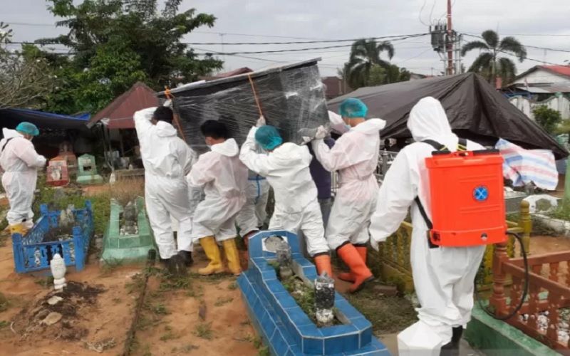 Tim KBR Brimob Polda Kalimantan Selatan membantu memakamkan jenazah pasien Covid-19. - Antara