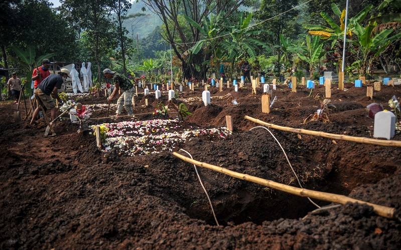 Petugas menggali liang lahat di lahan baru pemakaman khusus Covid-19 di TPU Kihafit, Leuwigajah, Cimahi, Jawa Barat, Minggu (8/8/2021). Pemerintah Kota Cimahi menjadikan TPU Kihafit sebagai lahan pemakaman baru bagi pasien yang meninggal dunia akibat Covid-19 dengan daya tampung 170 liang. ANTARA FOTO - Raisan Al Farisi