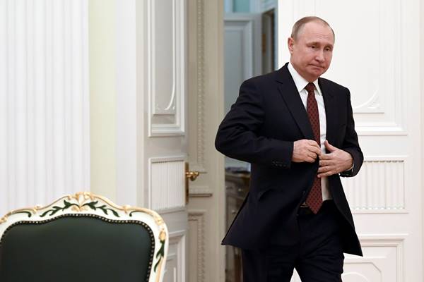 Presiden Rusia Vladimir Putin memasuki aula untuk bertemu dengan kandidat yang berpartisipasi dalam pemilihan presiden sesi terakhir, di Kremlin di Moskow. - Reuters