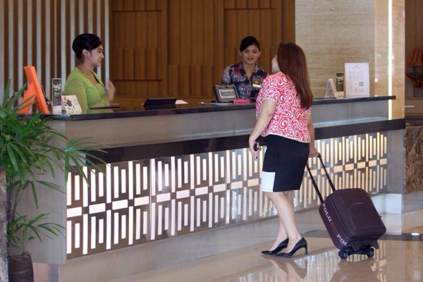 Resepsionis hotel sedang melayani calon konsumen. - Ilustrasi/Bisnis/Amri Nur Rahmat