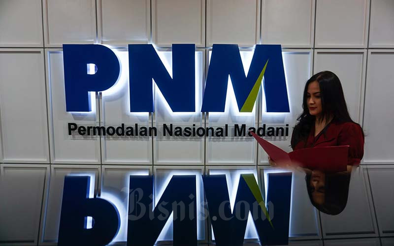 Karyawati beraktivitas di dekat logo PT Permodalan Nasional Madani (PNM) di Jakarta, Rabu (19/1/2022). Bisnis - Suselo Jati