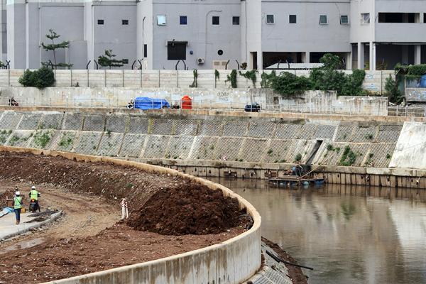 Pekerja melintas di area pembangunan turap bantaran Sungai Ciliwung, di kawasan Kampung Melayu, Jakarta, Rabu (22/3). - Antara/Risky Andrianto