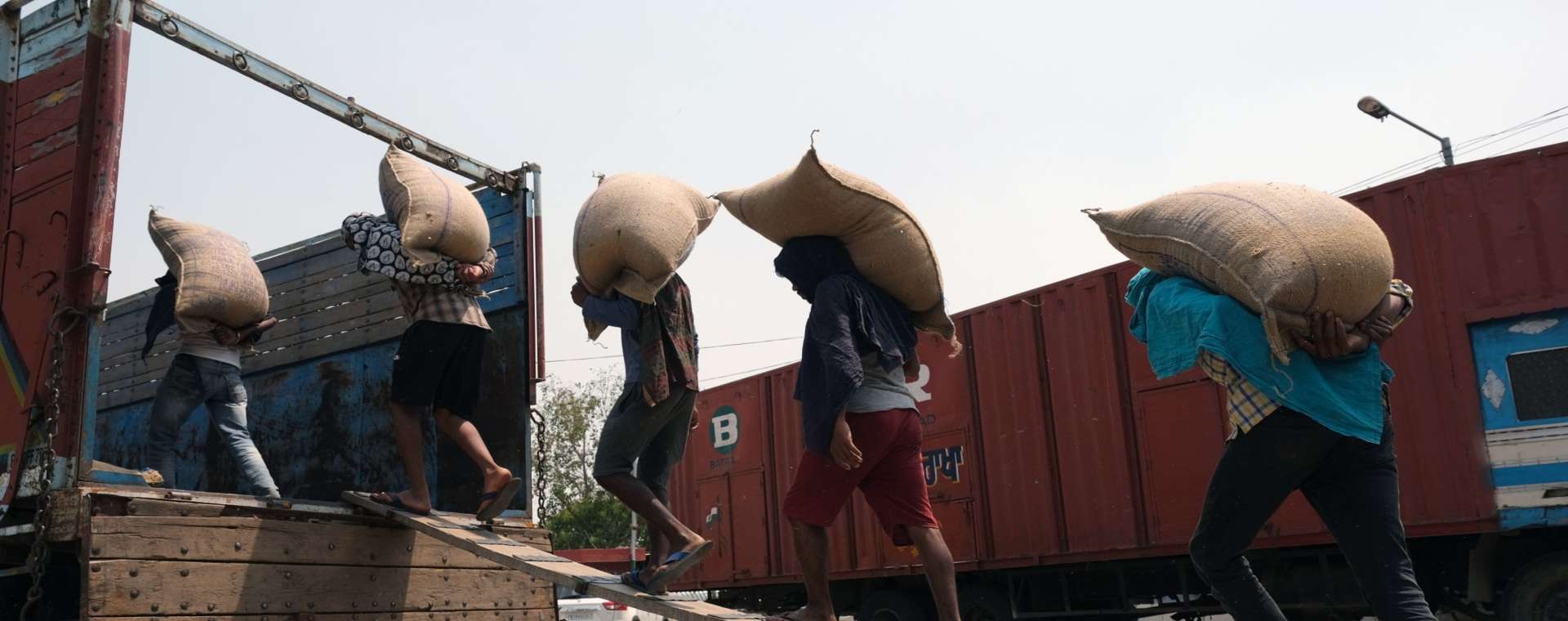 Buruh memuat karung gandum di atas truk di pasar gandum di distrik Khanna di Punjab, India, pada Sabtu, 30 April 2022.