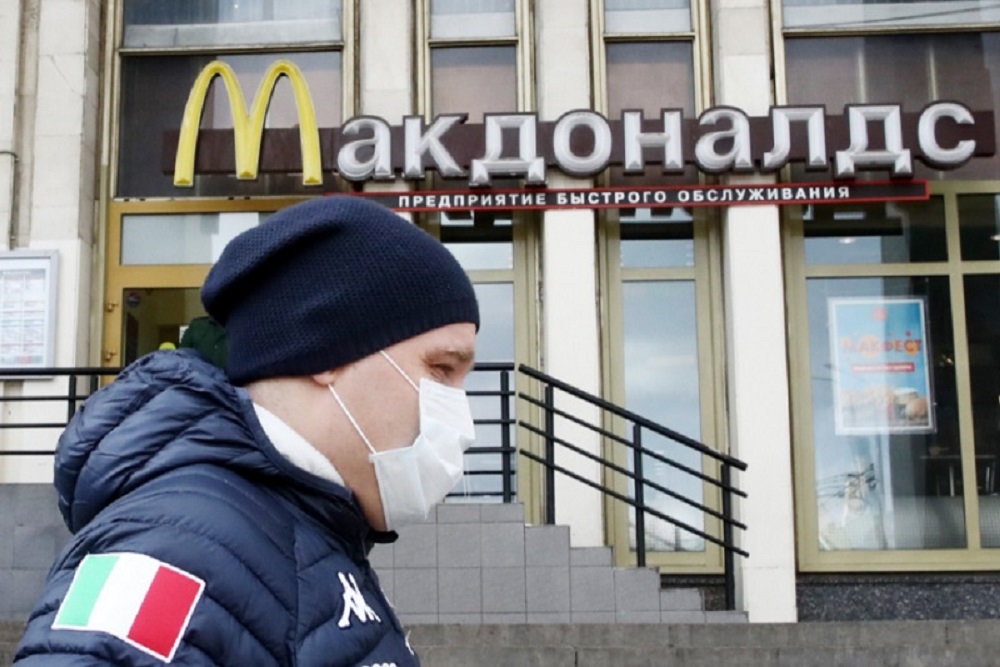 Seorang warga melewati gerai McDonald's di Moscow, Rusia yang telah tutup - The Moscow Times