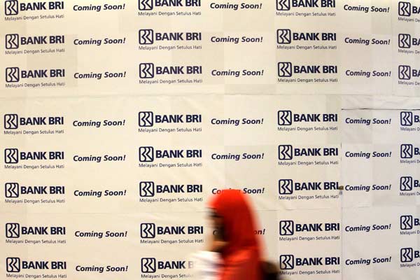 Pengunjung melintasi logo Bank BRI di sebuah pusat perbelanjaan di Jakarta, Senin (13/4). - Bisnis.com