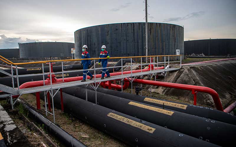 Pekerja PT Pertamina Hulu Rokan mengecek saluran pipa minyak yang menuju tangki pengumpul produksi minyak (Tank Farm) di Blok Rokan, Dumai, Riau, Rabu (22/12/2021). ANTARA FOTO - Nova Wahyudi