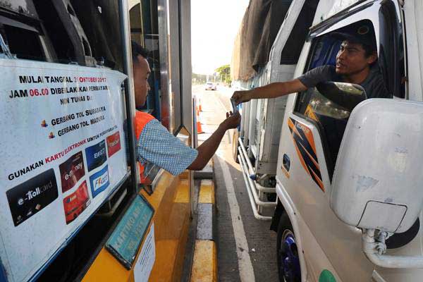 Pengendara truk membeli kartu elektronik tol (E-Toll) di loket pintu masuk Jembatan Suramadu, Surabaya, Jawa Timur, Selasa (31/10). Terhitung mulai Selasa (31/10). - ANTARA/Didik Suhartono