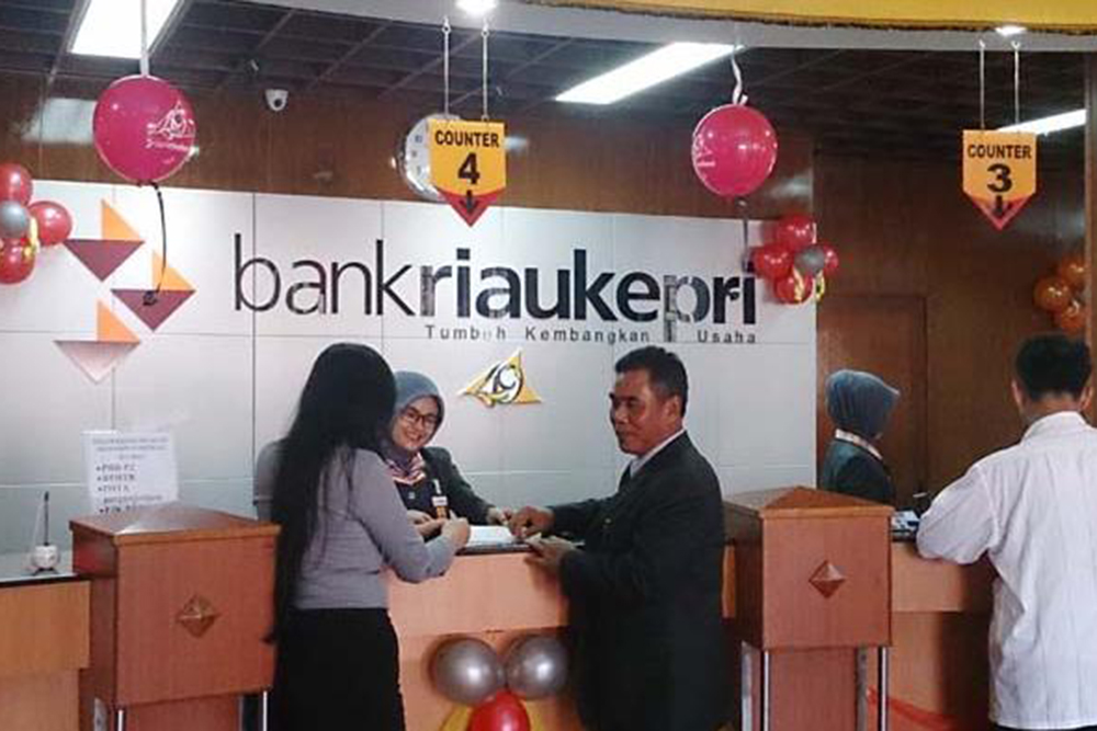 Karyawan Bank Riau Kepri melayani nasabah melalui kantor cabang.  - Asbanda