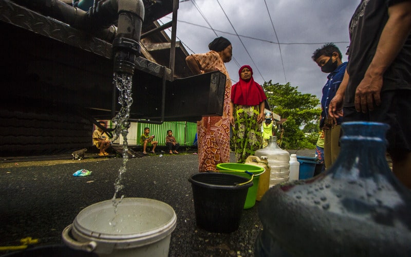 Sejumlah warga antre untuk mendapatkan air bersih di Kelurahan Pelambuan, Banjarmasin, Kalimantan Selatan, Minggu (15/5/2022). Warga di daerah tersebut kesulitan mendapatkan air bersih akibat pasokan dari Perusahaan Daerah Air Minum (PDAM) Banjarmasin mengalami penurunan bahkan tidak mengalir sejak dua bulan terakhir sehingga warga terpaksa menggunakan air aliran sungai serta membeli air bersih untuk memenuhi kebutuhan sehari-hari. - Antara/Bayu Pratama S.