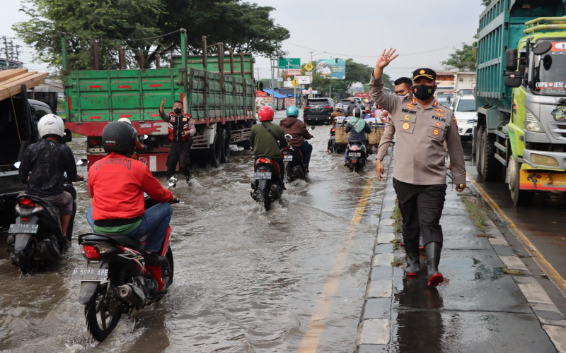 Kapolres Demak, AKBP Budi Adhy Buono (kanan), memantau langsung arus lalu lintas di wilayah Demak yang terganggu banjir rob pada Senin (23/5/2022). - Istimewa/Polda Jateng
