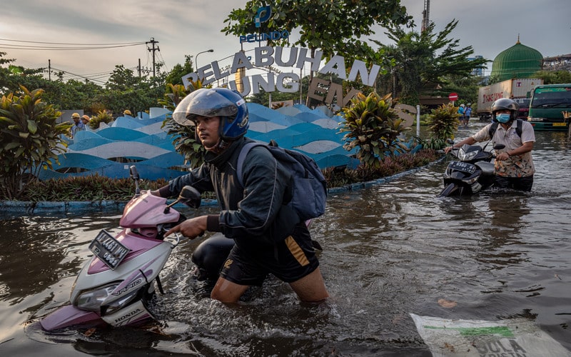 Sejumlah pekerja mendorong motornya yang mogok untuk menerobos banjir limpasan air laut ke daratan atau rob yang merendam kawasan Pelabuhan Tanjung Emas Semarang, Jawa Tengah, Senin (23/5/2022). - Antara/Aji Styawan.