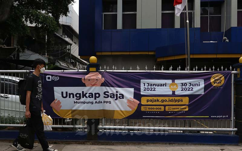 Warga melintasi spanduk Program Pengungkapan Sukarela (PPS) di salah satu kantor pelayanan pajak pratama di Jakarta, Senin (17/1/2022).  - Bisnis/Eusebio Chrysnamurti