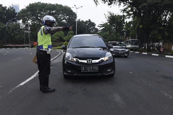 Polisi memberhentikan mobil berplat nomor ganjil yang melintas pada tanggal genap di kawasan pembatasan lalu lintas ganjil-genap di sekitar Bundaran Senayan, Jakarta, Selasa (30/8). - Antara