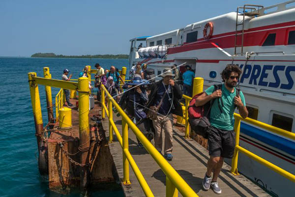Wisatawan berjalan di dermaga setelah kapal yang mereka tumpangi tiba di Pulau Karimunjawa.Foto: Antara