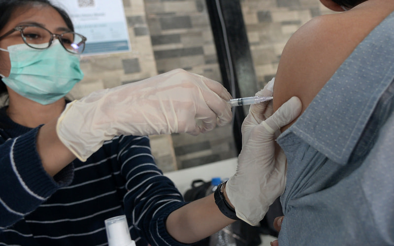 Petugas kesehatan menyuntikkan vaksin ke warga di salah satu pusat perbelanjaan di Manado, Sulawesi Utara Kamis (14/4/2022). Berdasarkan data dari Dinas Kesehatan Sulut per tanggal 12 April 2022, tercatat capaian vaksinasi booster di Sulut mencapai 10,93 persen, mendekati capaian Nasional di angka 12,95 persen. - Antara/Adwit B Pramono.