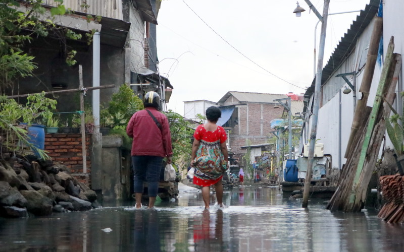 Ilustrasi - Warga Tambak Lorok melintasi jalan yang tergenang banjir rob. - Bisnis/Muhammad Faisal Nur Ikhsan