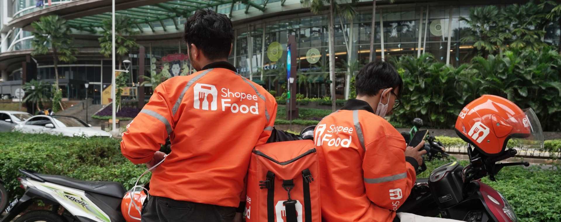 Pengemudi Shopeefood tampak sedang menunggu di depan sebuah pusat perbelanjaan di Jakarta, Senin, (15/3 - 2021). Shopee tengah diterpa badai PHK menyusul penurunan valuasi perusahaan induknya, Sea Ltd. Bloomberg / Dimas Ardian