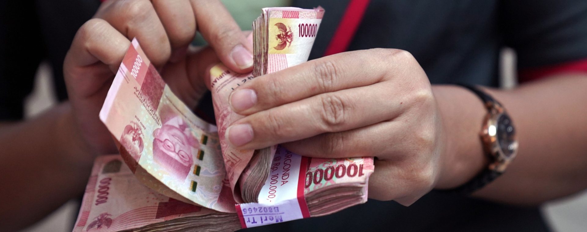 Seorang karyawan menghitung uang kertas Rp100.000 di penukaran mata uang PT Ayu Masagung di Jakarta, Selasa, (18/8 - 2020). Bloomberg / Dimas Ardian