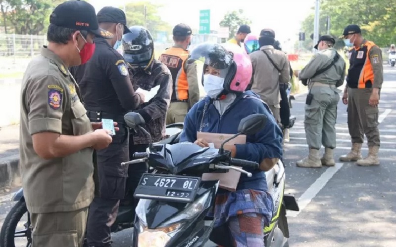 Sejumlah petugas melakukan pemeriksaan kepada warga yang hendak ke Kota Surabaya melalui Jembatan Suramadu, Selasa (15/6/2021). - Antara.