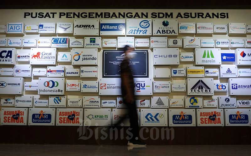 Karyawan beraktivitas di dekat logo-logo perusahaan asuransi di kantor Asosiasi Asuransi Umum Indonesia (AAUI) di Jakarta, Rabu (5/1/2021).  - Bisnis/Suselo Jati